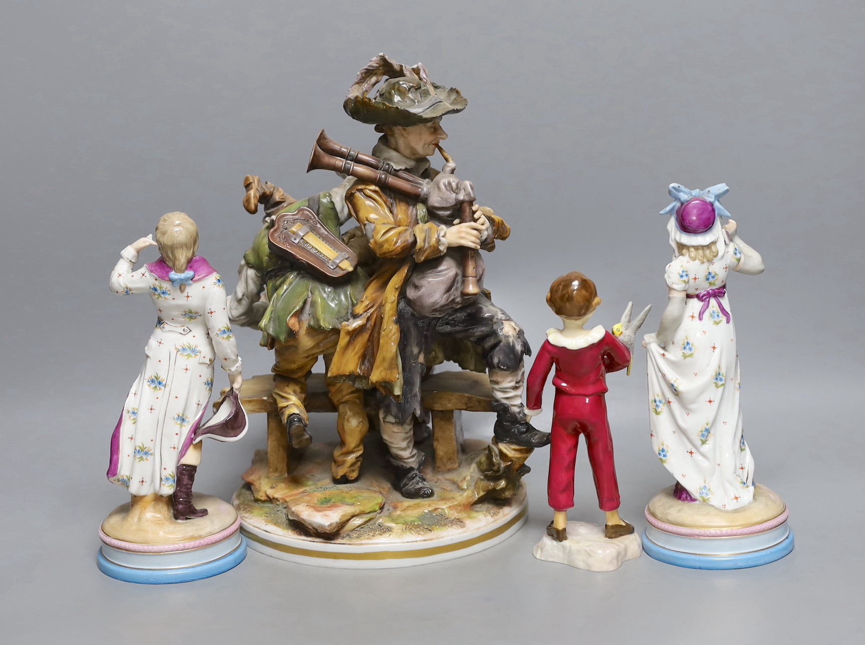 A pair of KPM style porcelain figures of a maiden and a gallant, 22cm, a Capo di Monte figure group, 29cm, and a Royal Worcester figure 'The Parakeet', modelled by F.G. Doughty, no.3087